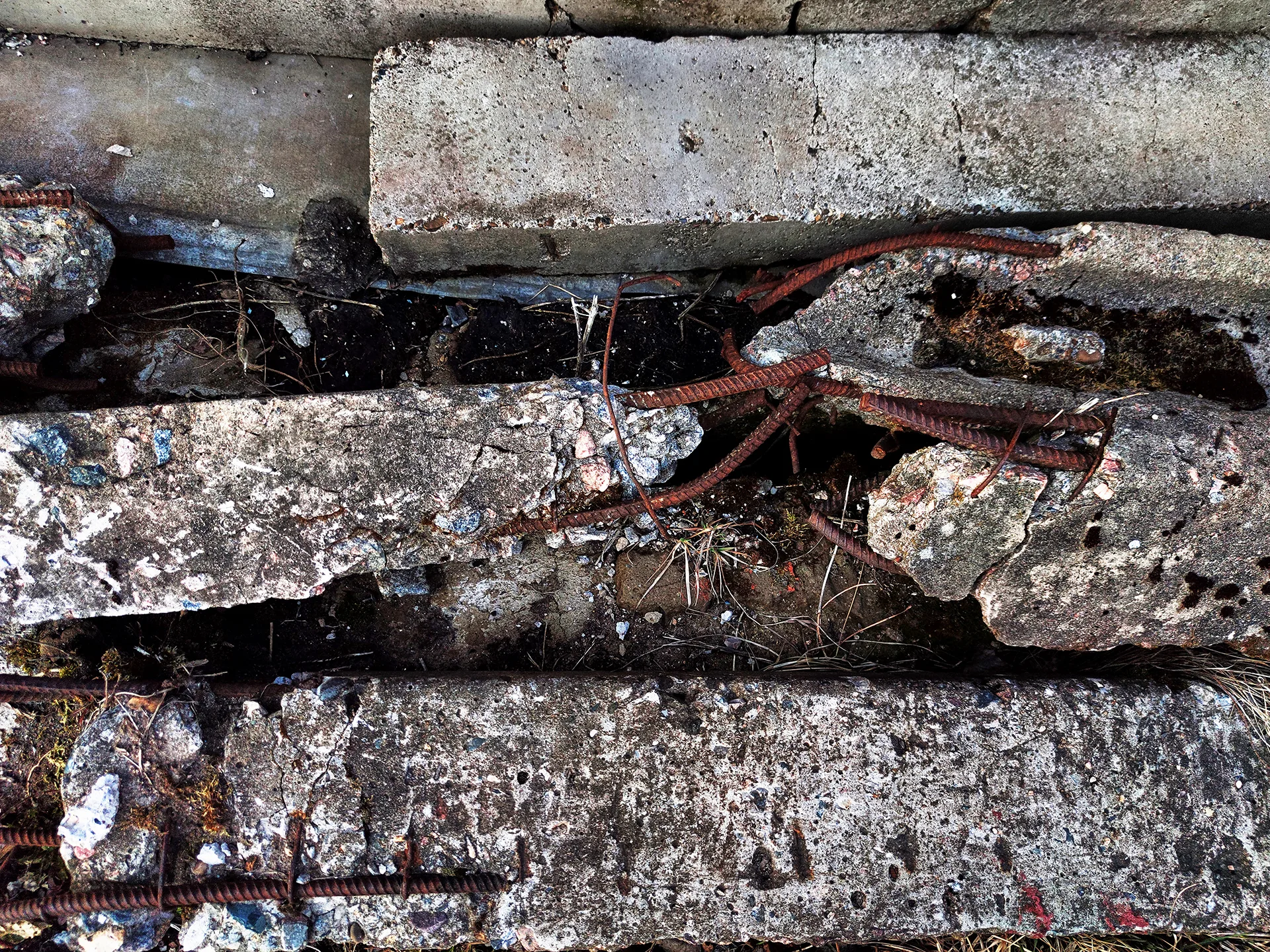 Severely damaged concrete with exposed and corroded reinforcement